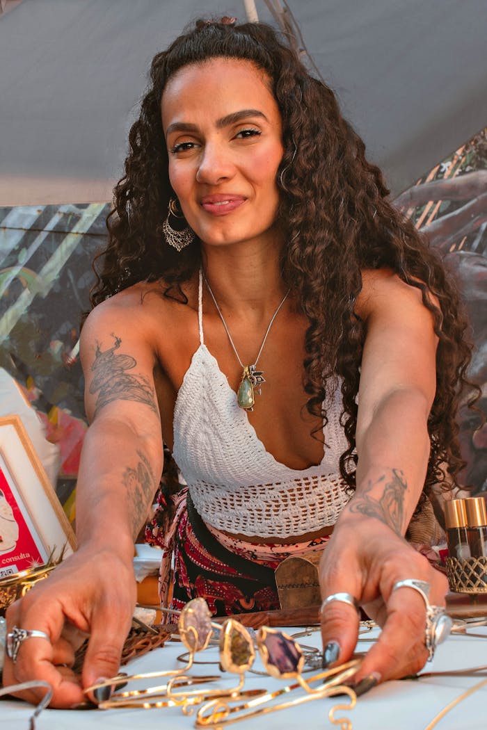 about-img-01 Artisan woman displaying unique handmade jewelry at a craft fair table.